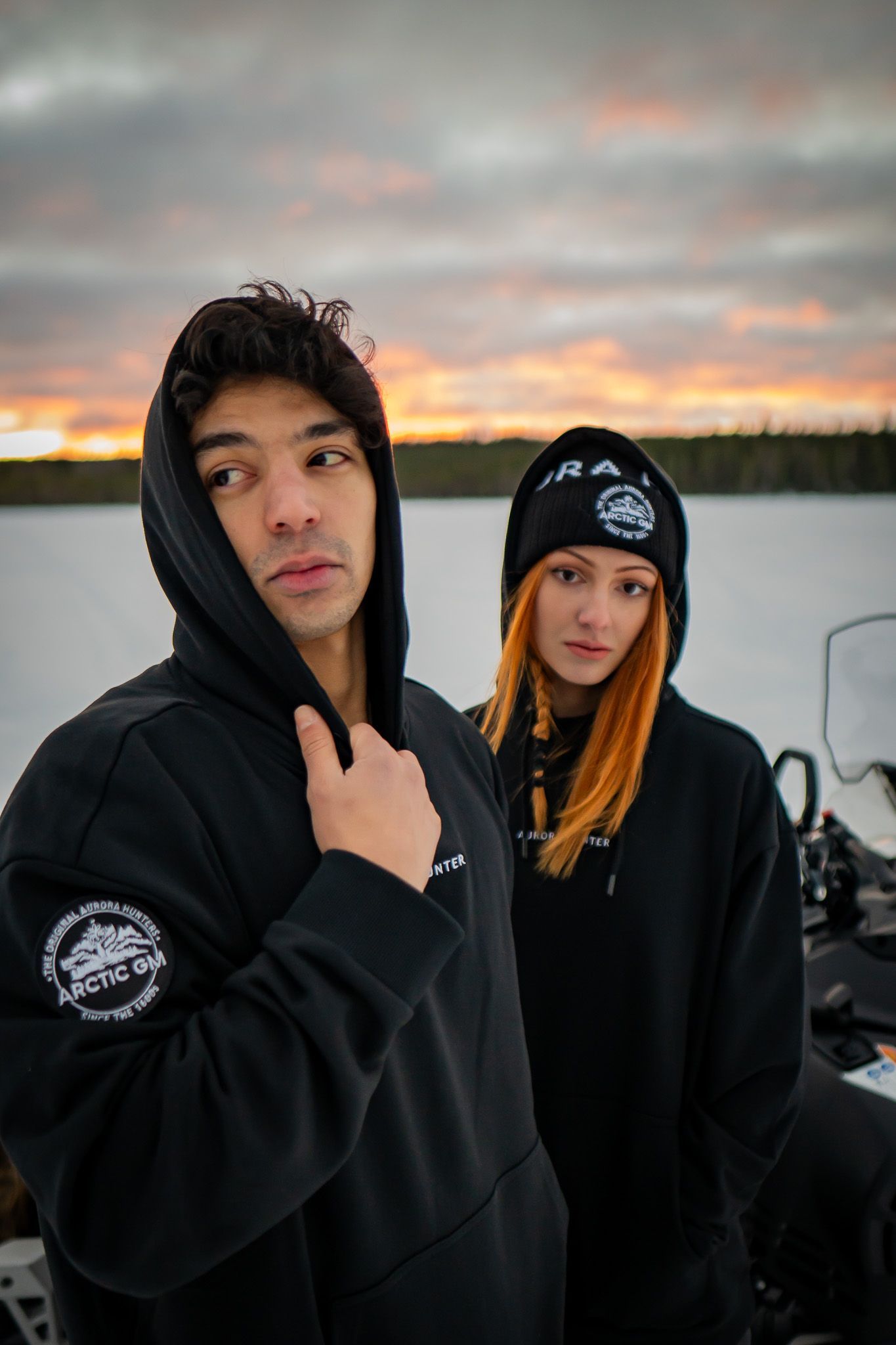 Close-up of Arctic GM hoodie with couple standing on frozen lake