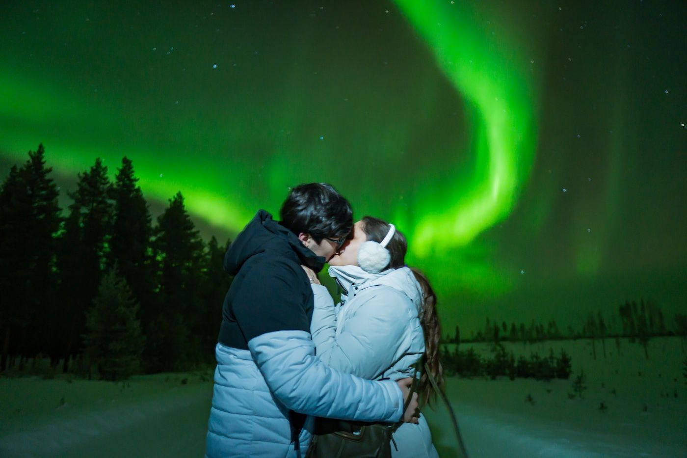 Couple sharing a kiss under the Aurora on private Arctic GM tour in Tromsø