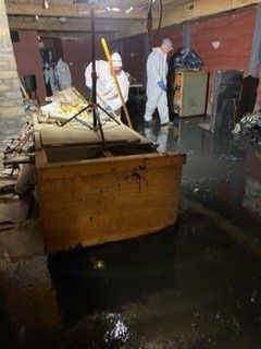 A group of people are working in a flooded basement.
