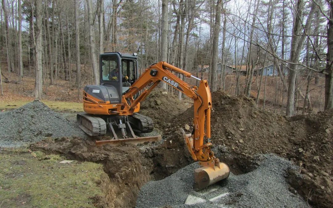 An excavator is digging a hole in the ground in the woods.