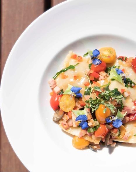 Primer plano de un tazón blanco lleno de sopa y dumplings. Texto