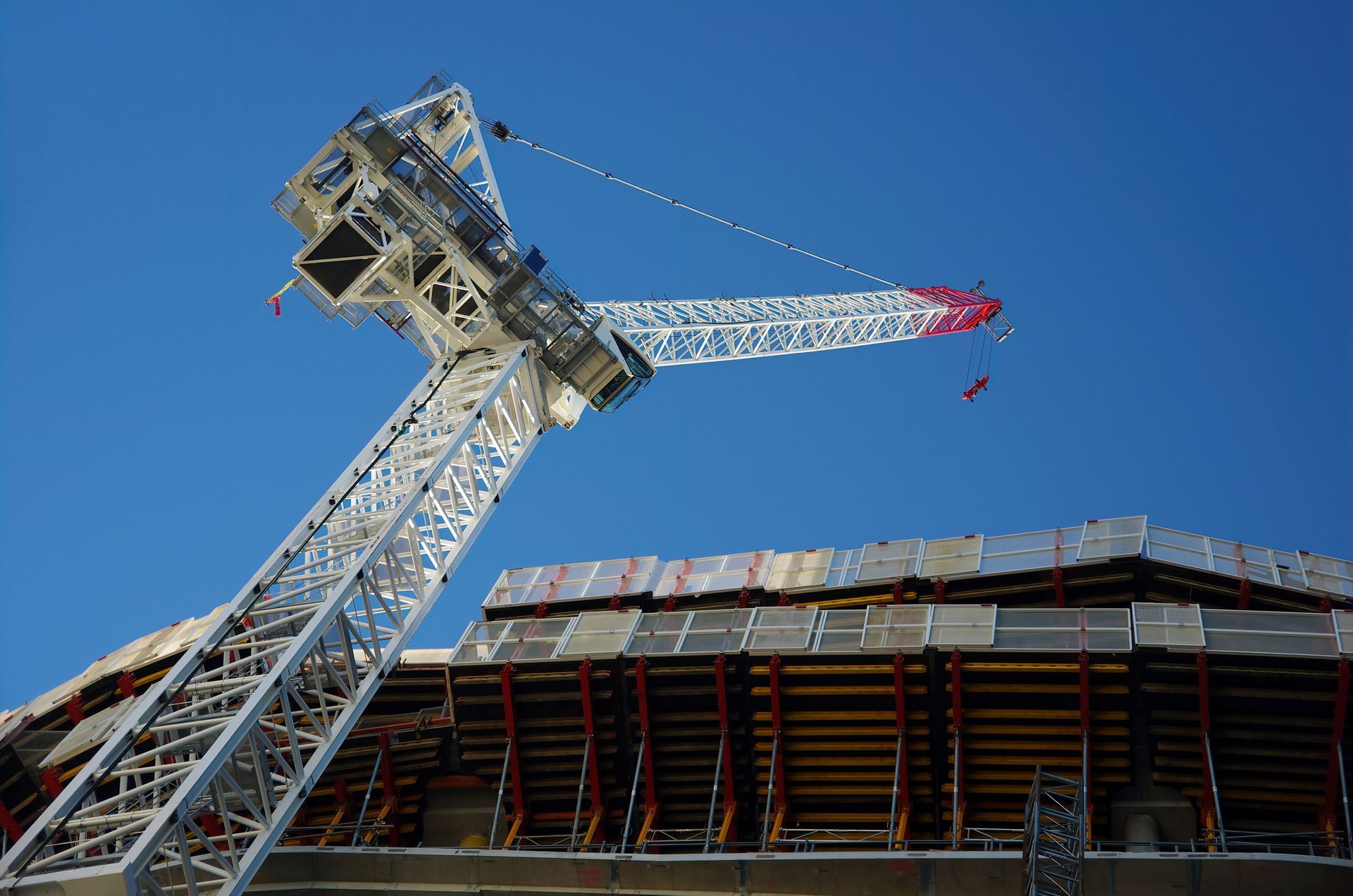 A large crane is sitting on top of a building under construction.