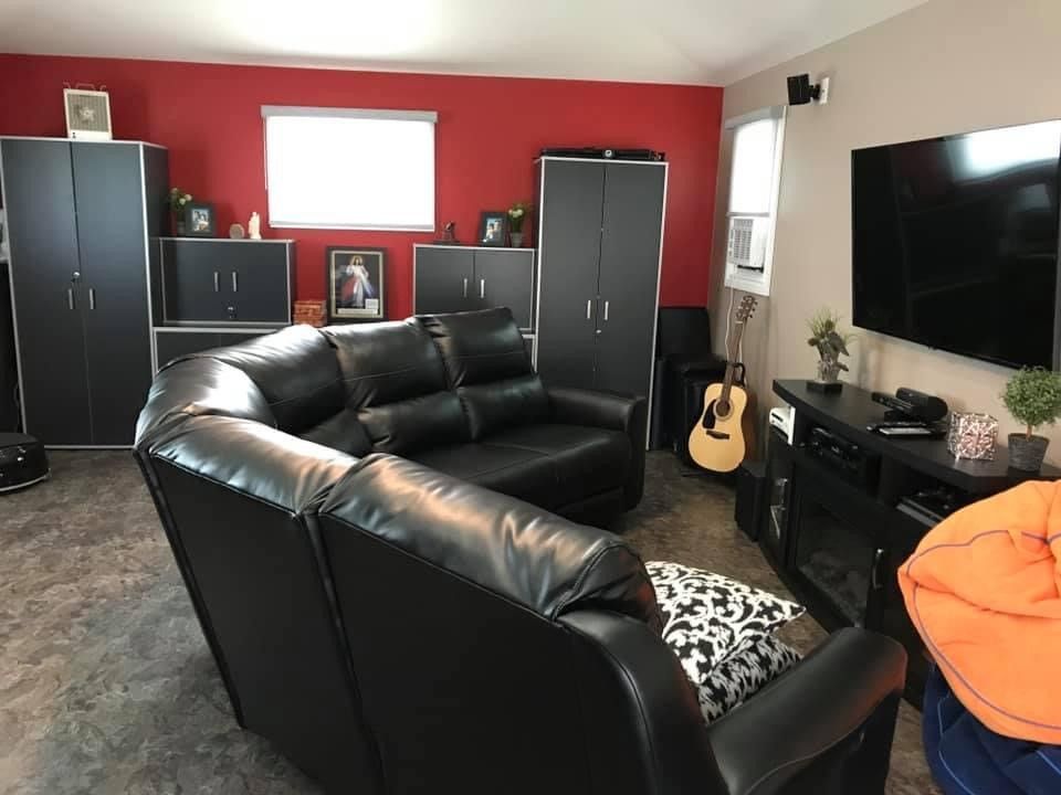 Living Room with a Black Couch and Guitar — Oldcastle, ON — Water Loc Inc