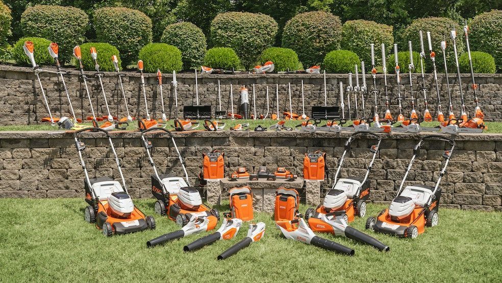 A Row of Lawn Mowers and Brush Cutters Are Lined up On a Lush Green Lawn — Stihl Shop Grafton in Grafton, NSW