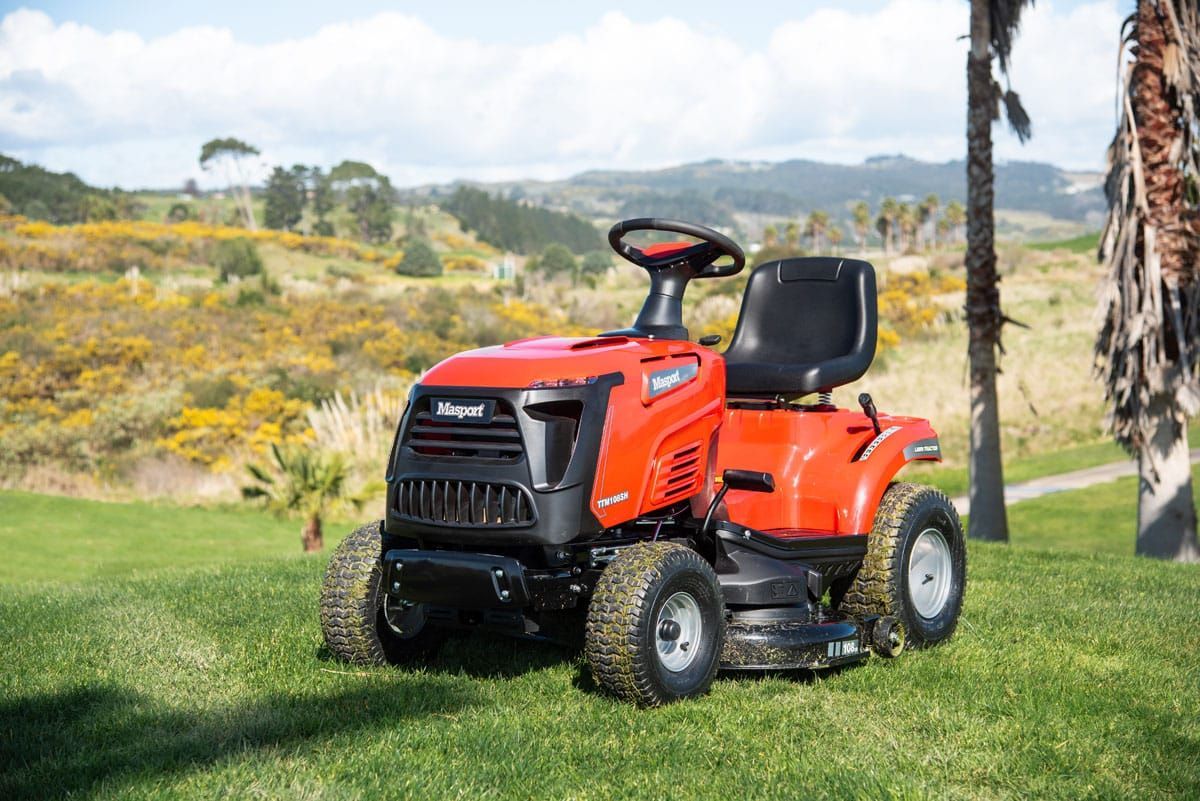 A Red Lawn Mower Is Parked on A Lush Green Field — Stihl Shop Grafton in Grafton, NSW