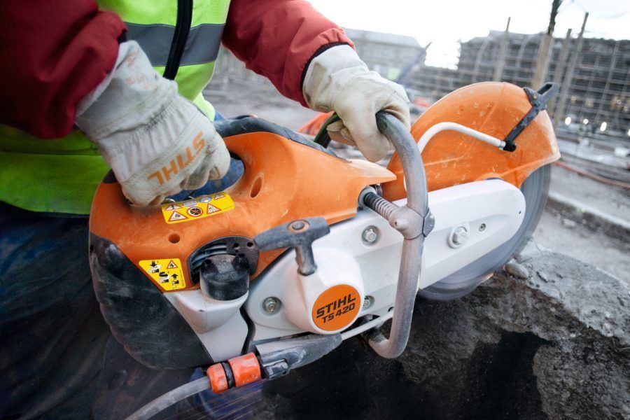 A Man Is Using a Stihl Circular Saw to Cut Concrete — Stihl Shop Grafton in Grafton, NSW