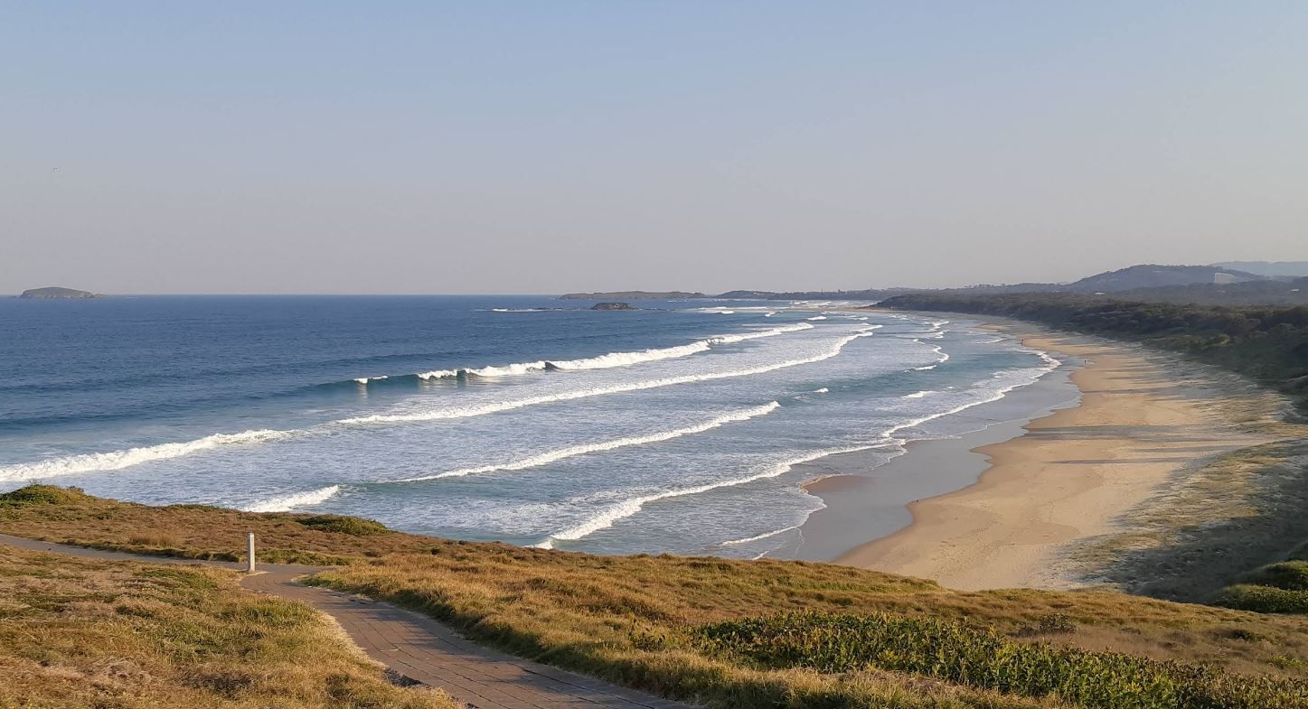 An Aerial View of A Beach with Waves Crashing on The Shore — Stihl Shop Grafton in Woolgoolga, NSW