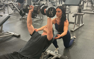 Three people are posing for a picture in a stadium.