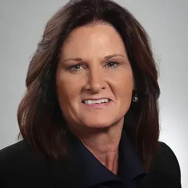 A close up of a woman 's face wearing a black jacket and smiling.