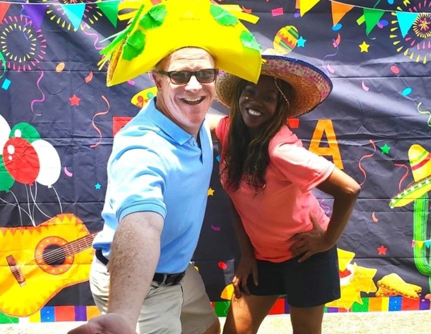 A man and a woman wearing sombrero hats pose for a picture