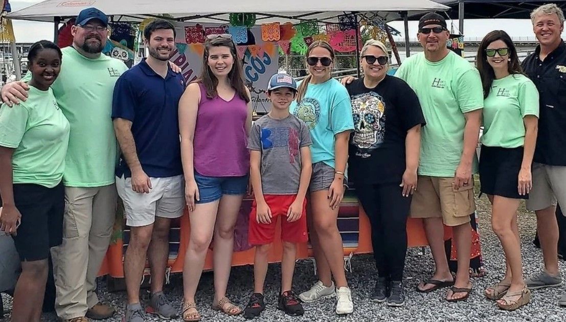 A group of people are posing for a picture in front of a tent.