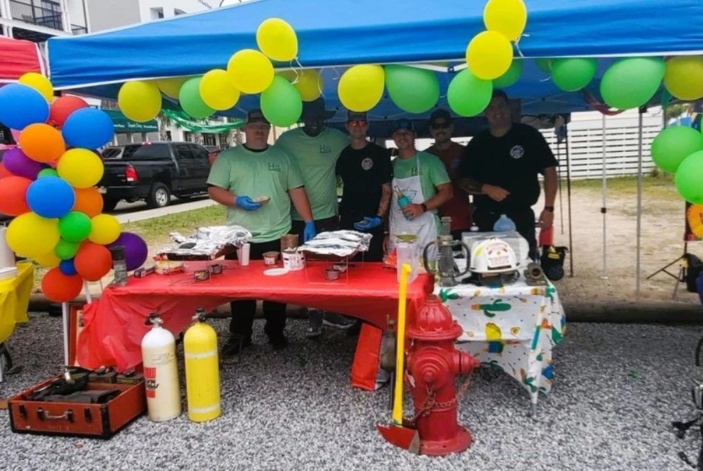 A group of people standing under a tent with balloons