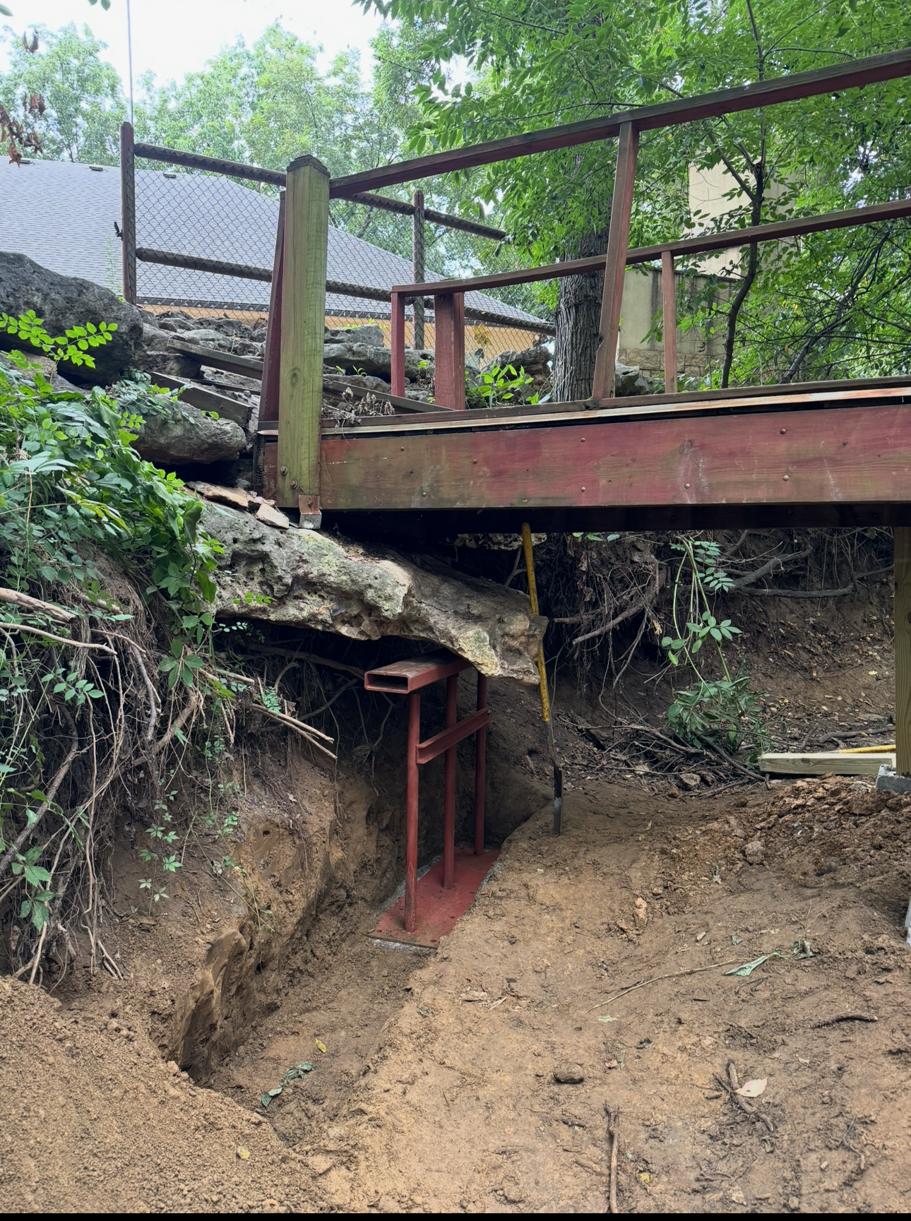 Deck over an excavated area, supported by a metal frame. Earthwork in progress.