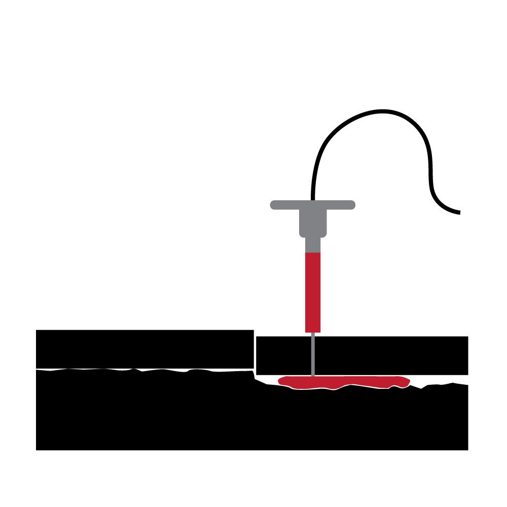 A red substance is being injected into a crevice between two black blocks with a syringe-like device.