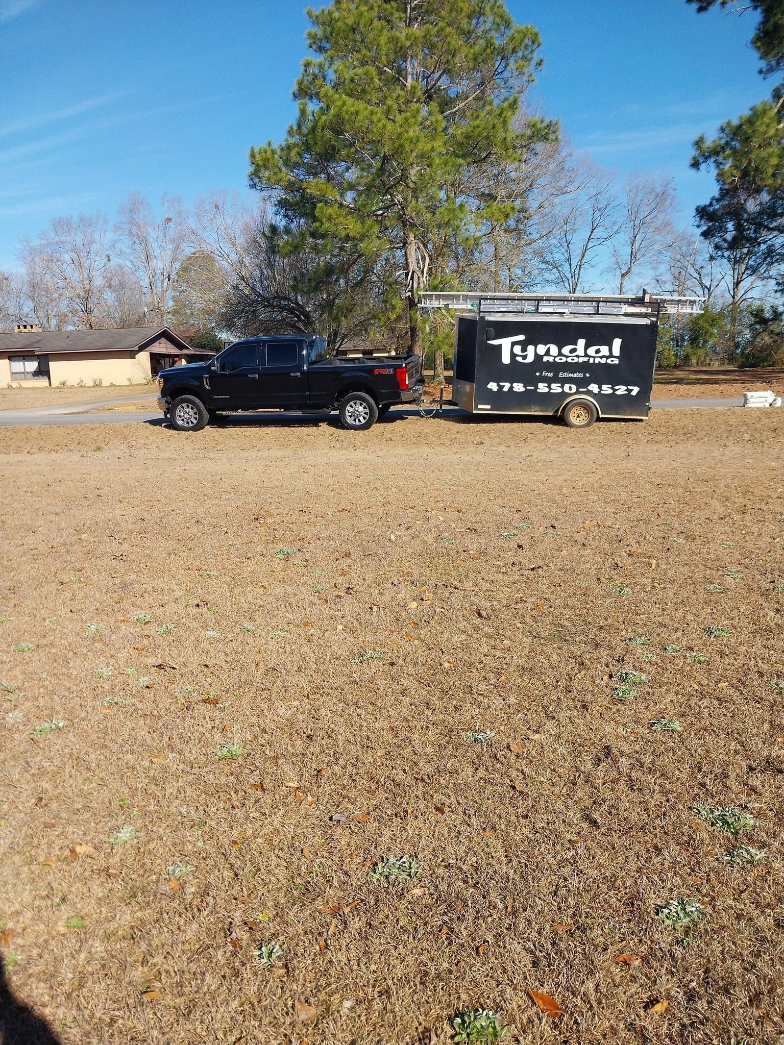 Black truck towing a black trailer with the words 