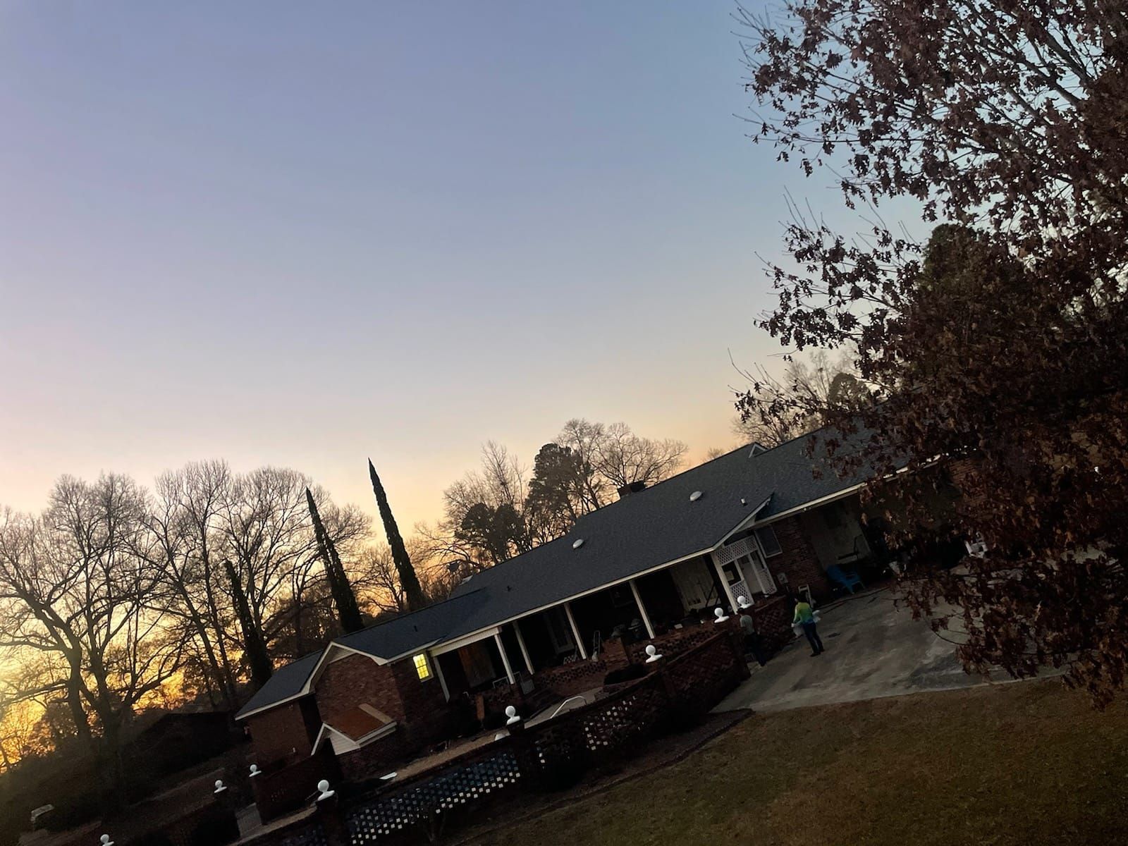 House at dusk with trees and a gradient sky.