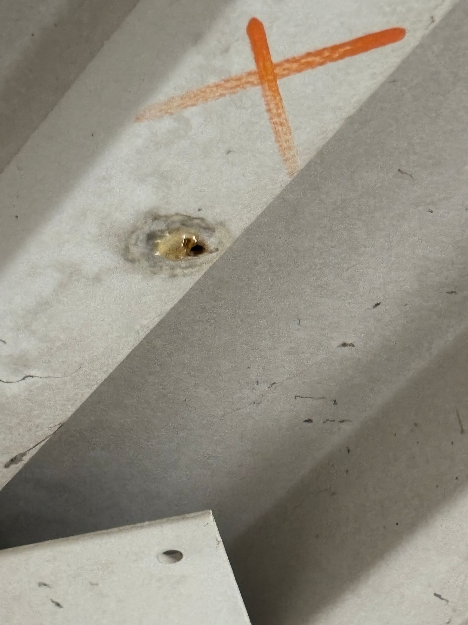 Close-up of a damaged metal surface with an orange 