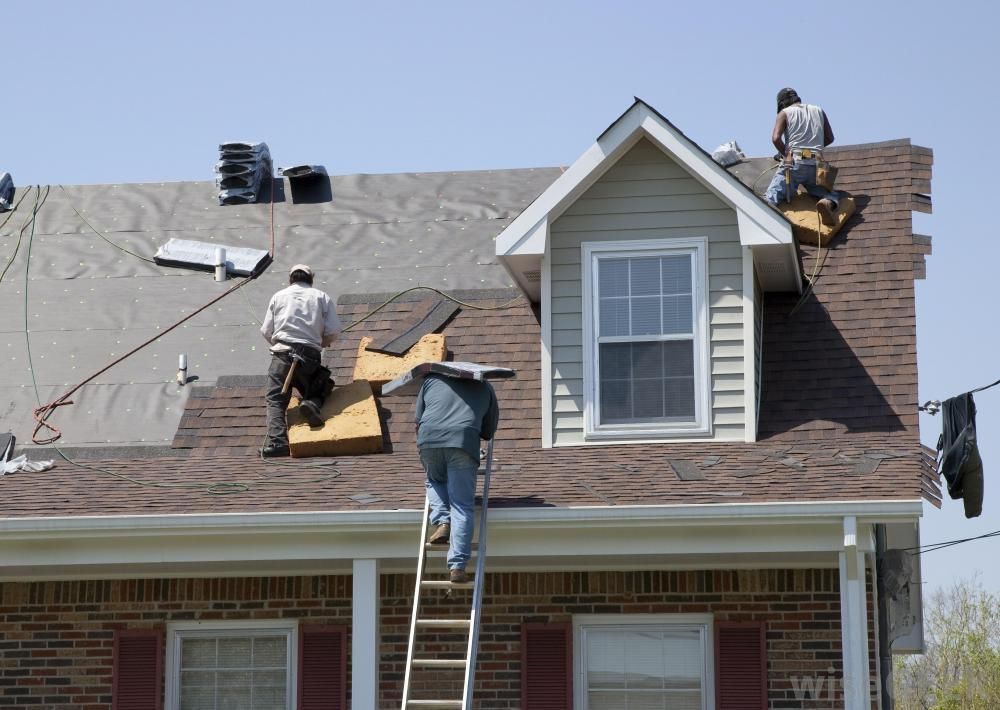 Workers repairing residential roof