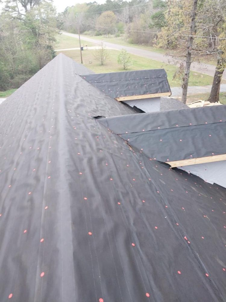 View of a roof covered with black underlayment, ready for shingles; outside setting.
