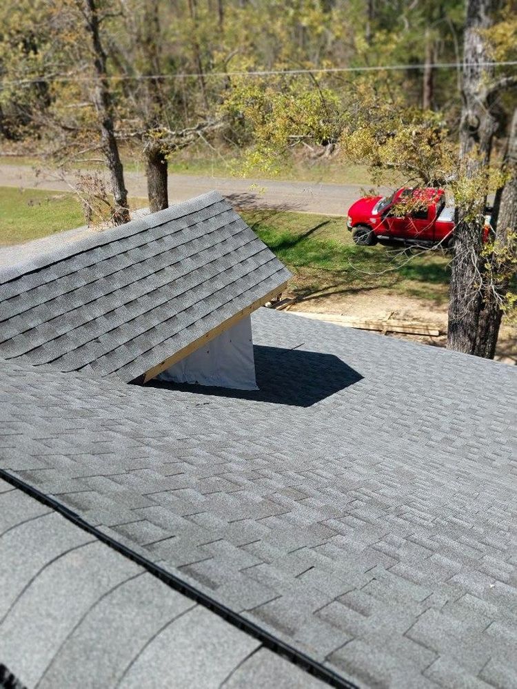 Gray shingled roof with a small, unfinished dormer; red truck in the distance.