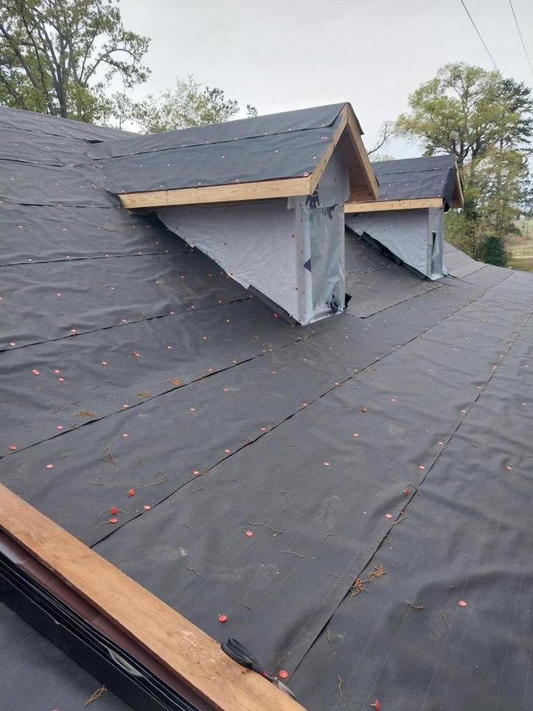 Rooftop with two dormers covered in black underlayment. Wooden frames show the shape of the dormers.