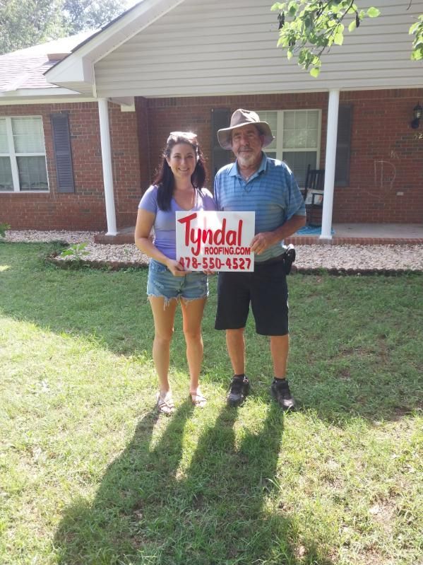 Woman and man holding a sign for 