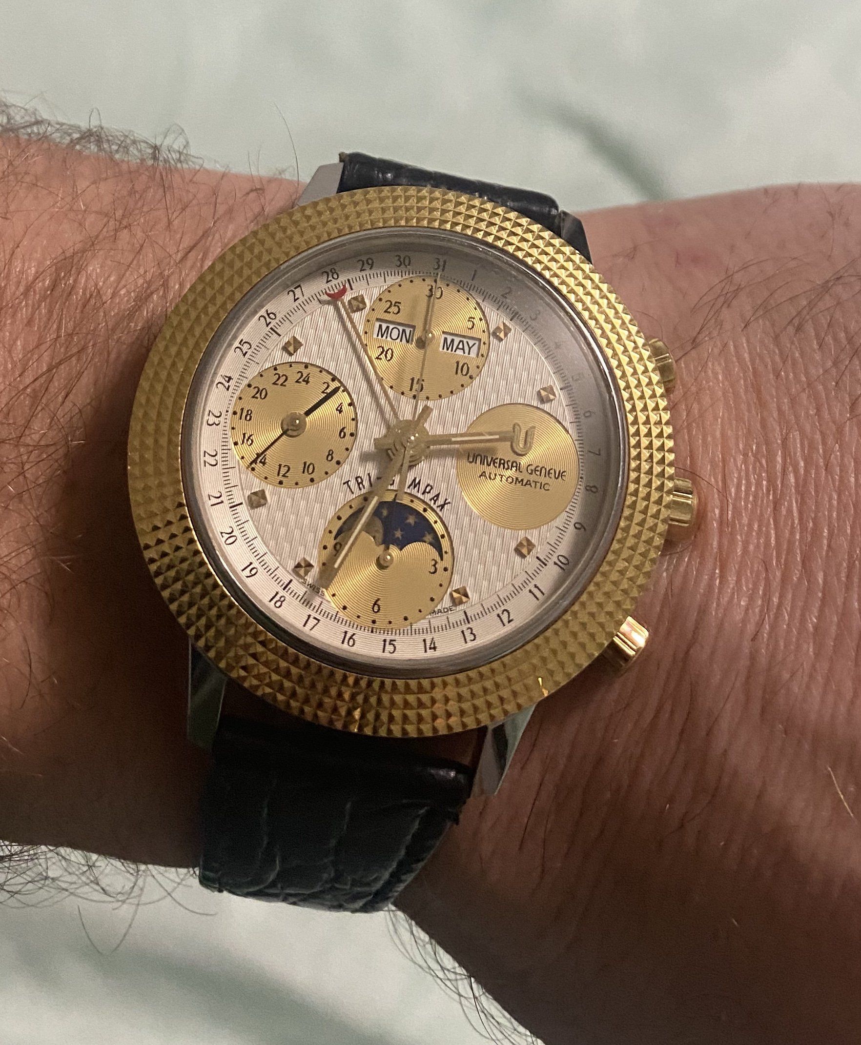 A man is wearing a gold watch on his wrist.