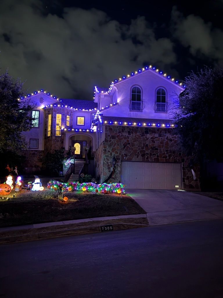 A house decorated with blue Halloween lights at night.