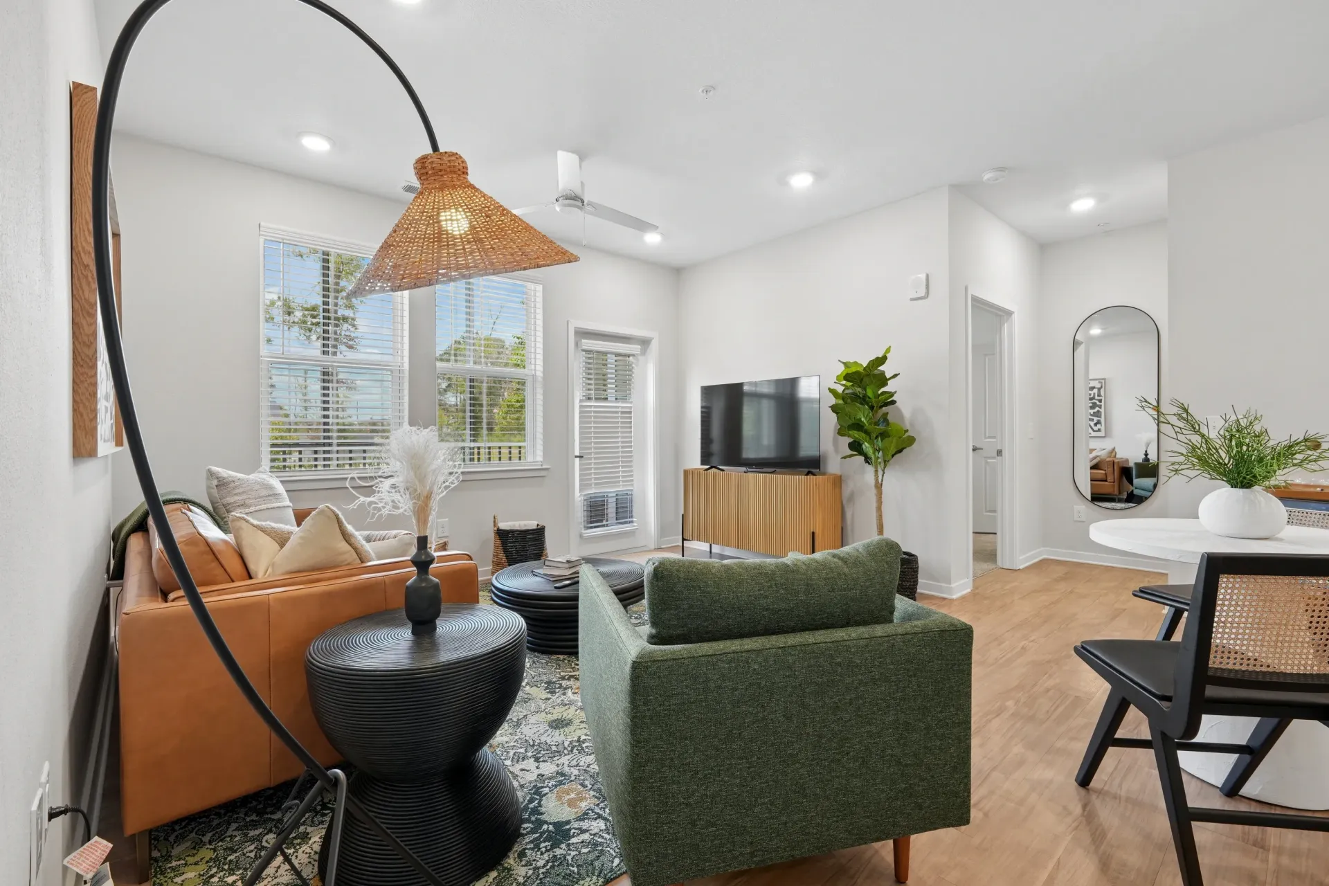 Living room featuring a leather sofa, green armchair, coffee table, and TV stand.