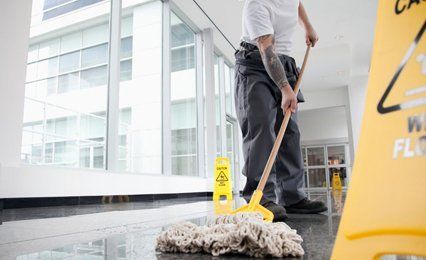 A man mopping a corridor floor