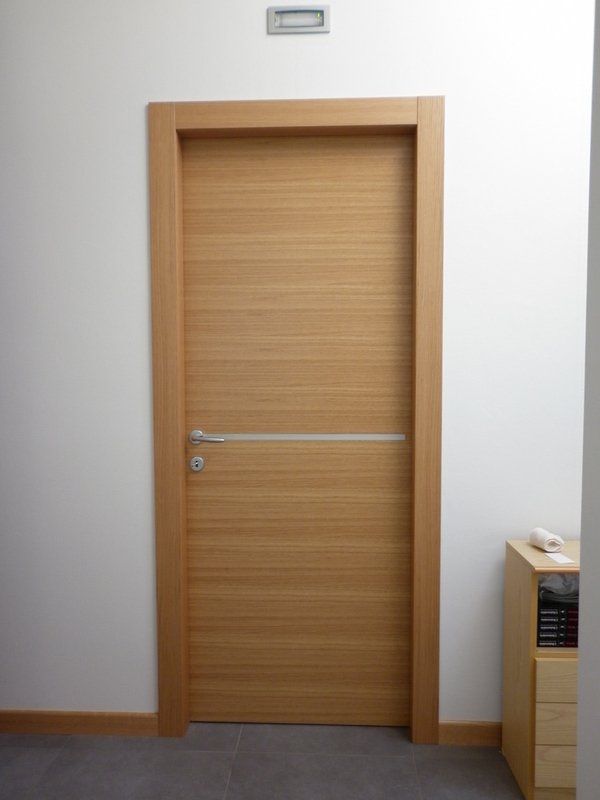 Una porta di legno in un corridoio con una parete bianca