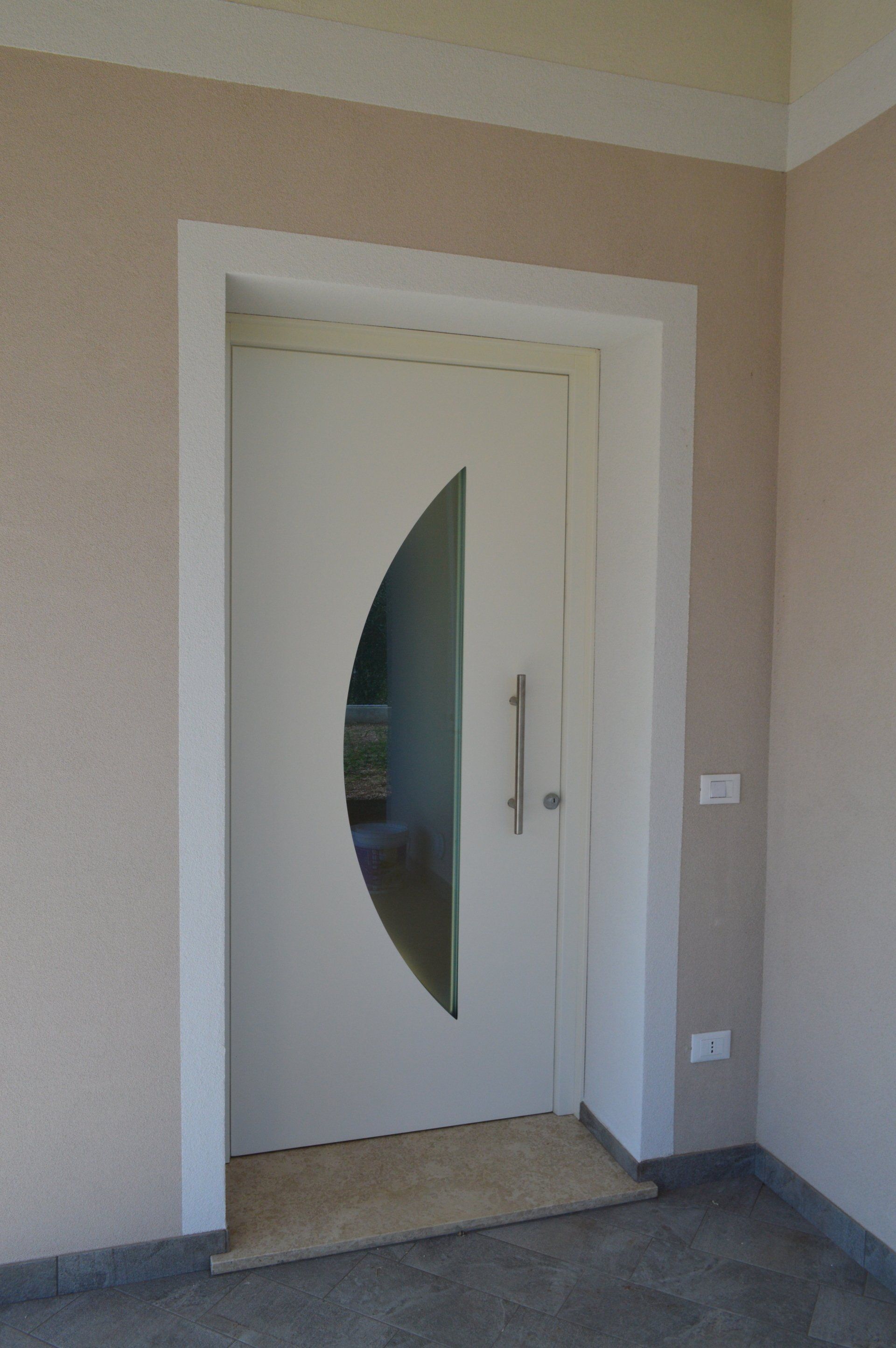 Una porta bianca con una finestra a mezzaluna in una stanza