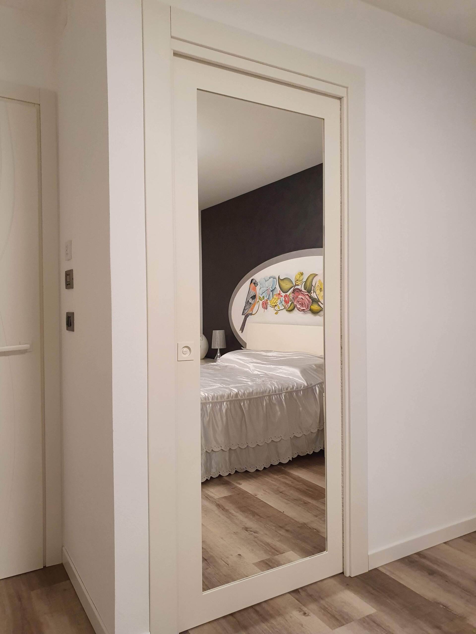 Una camera da letto con un letto e uno specchio sulla porta.