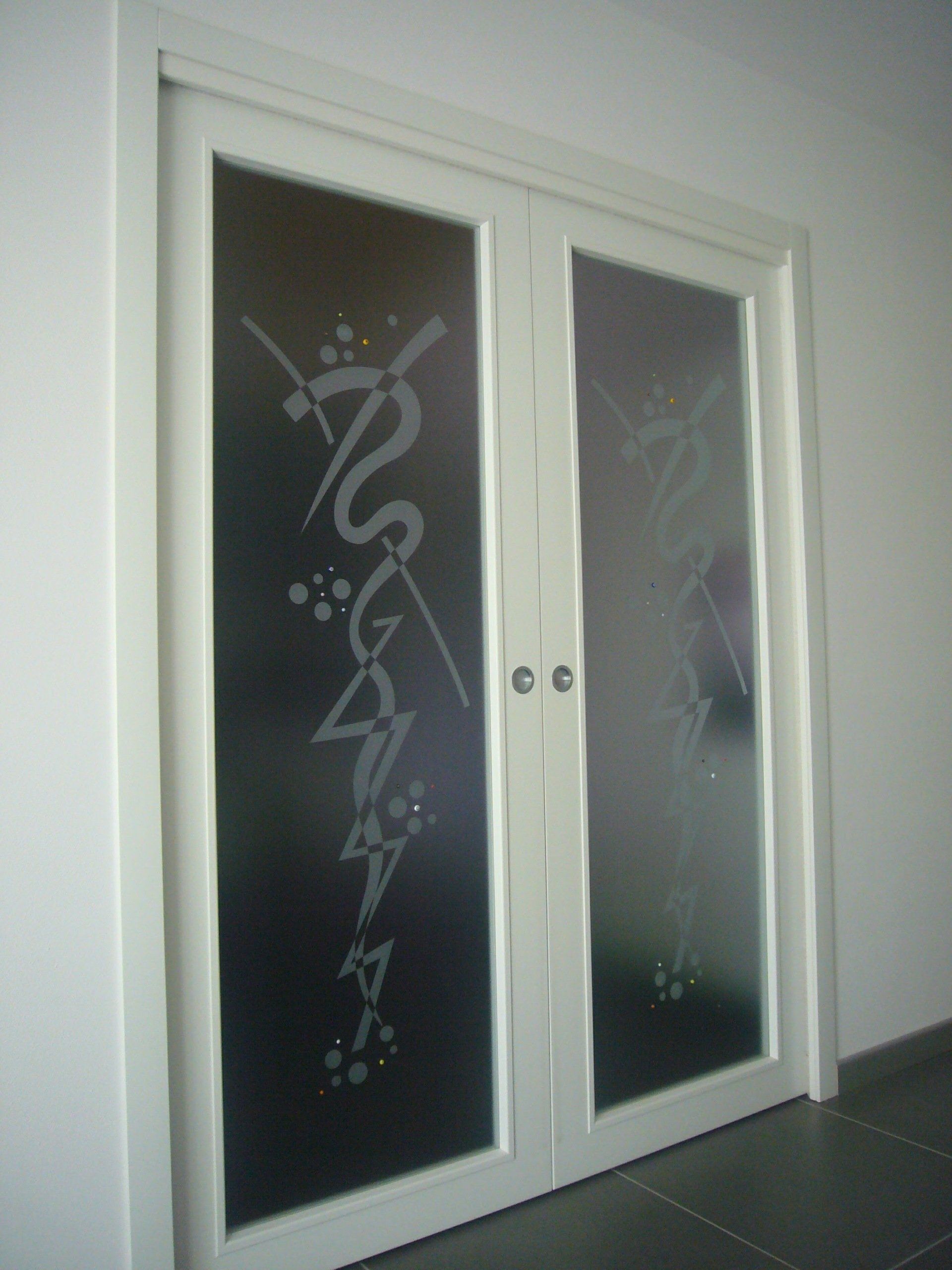 Una coppia di porte in vetro smerigliato con un disegno su di esse