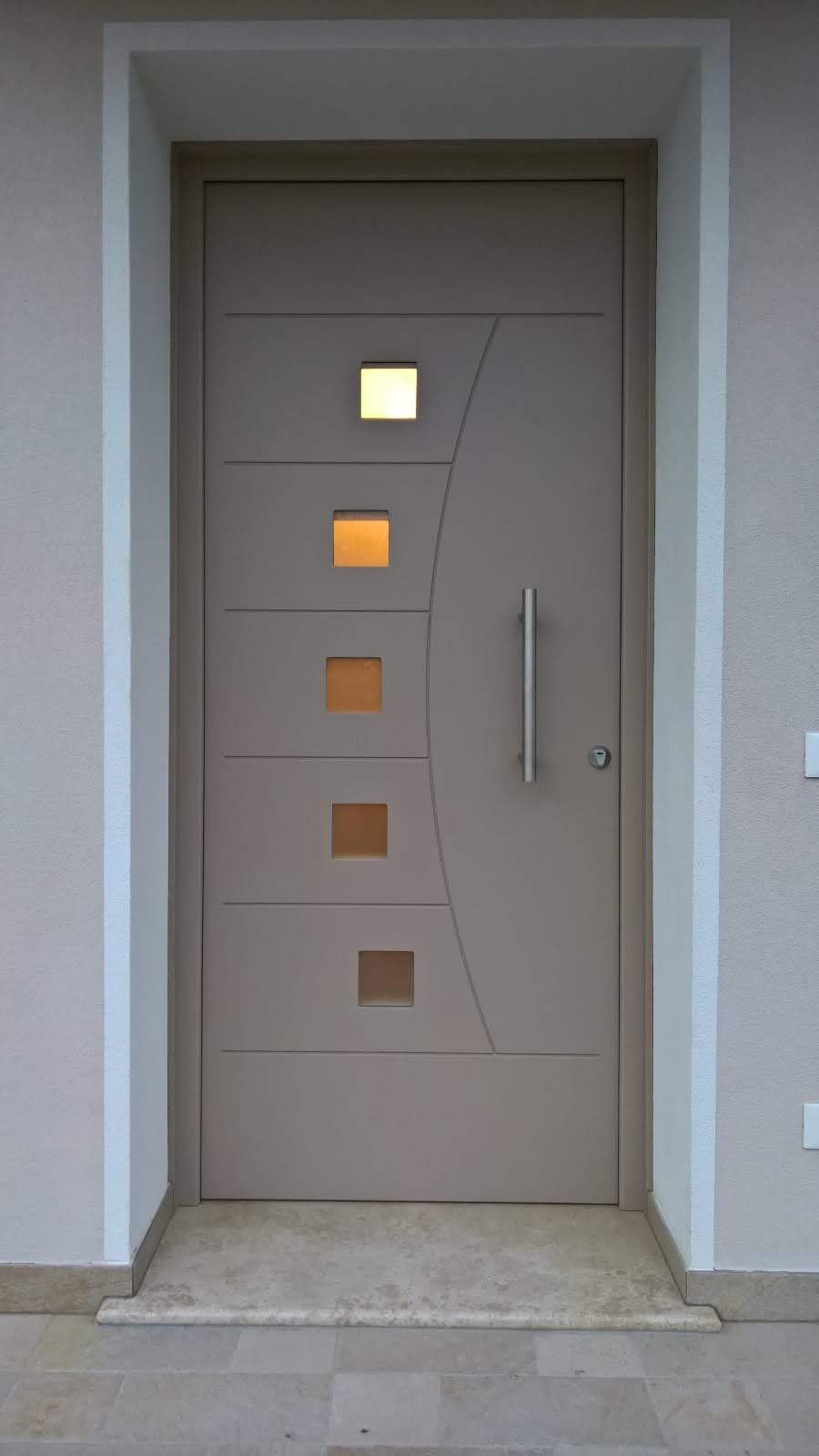 Primo piano di una porta con finestre quadrate e una maniglia.