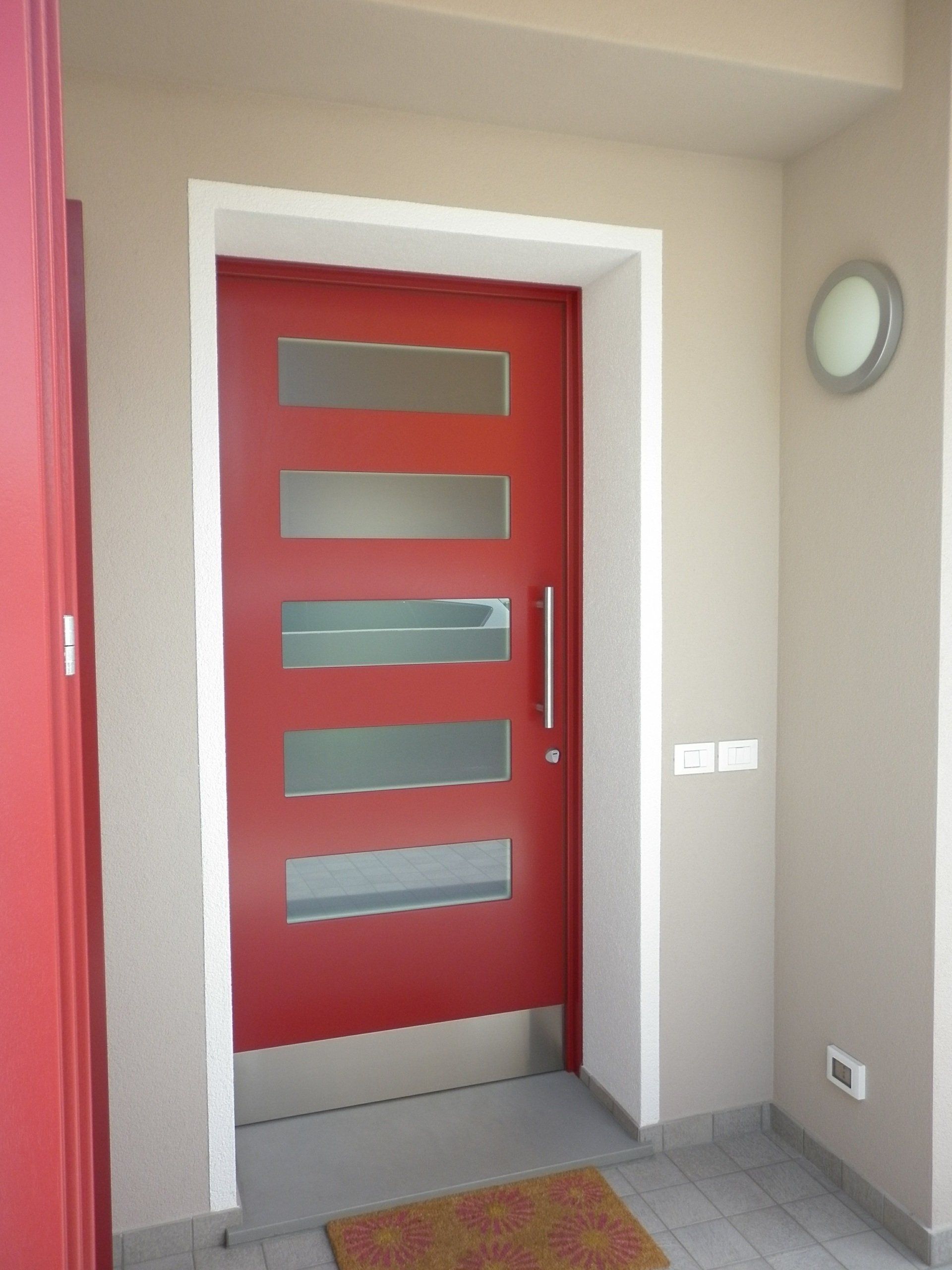 Una porta rossa con una maniglia in acciaio inossidabile