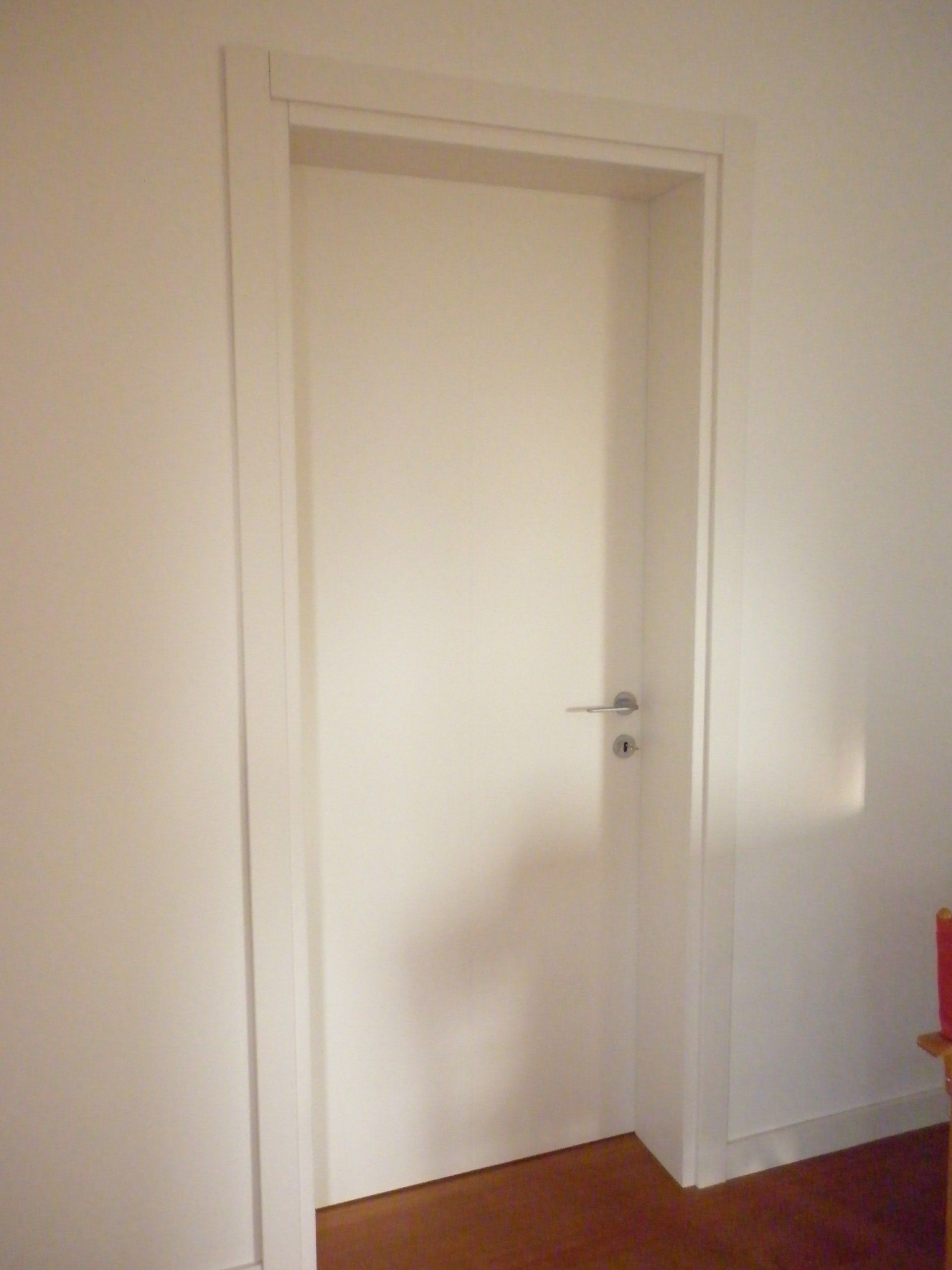 Una porta bianca in una stanza con pavimento in legno