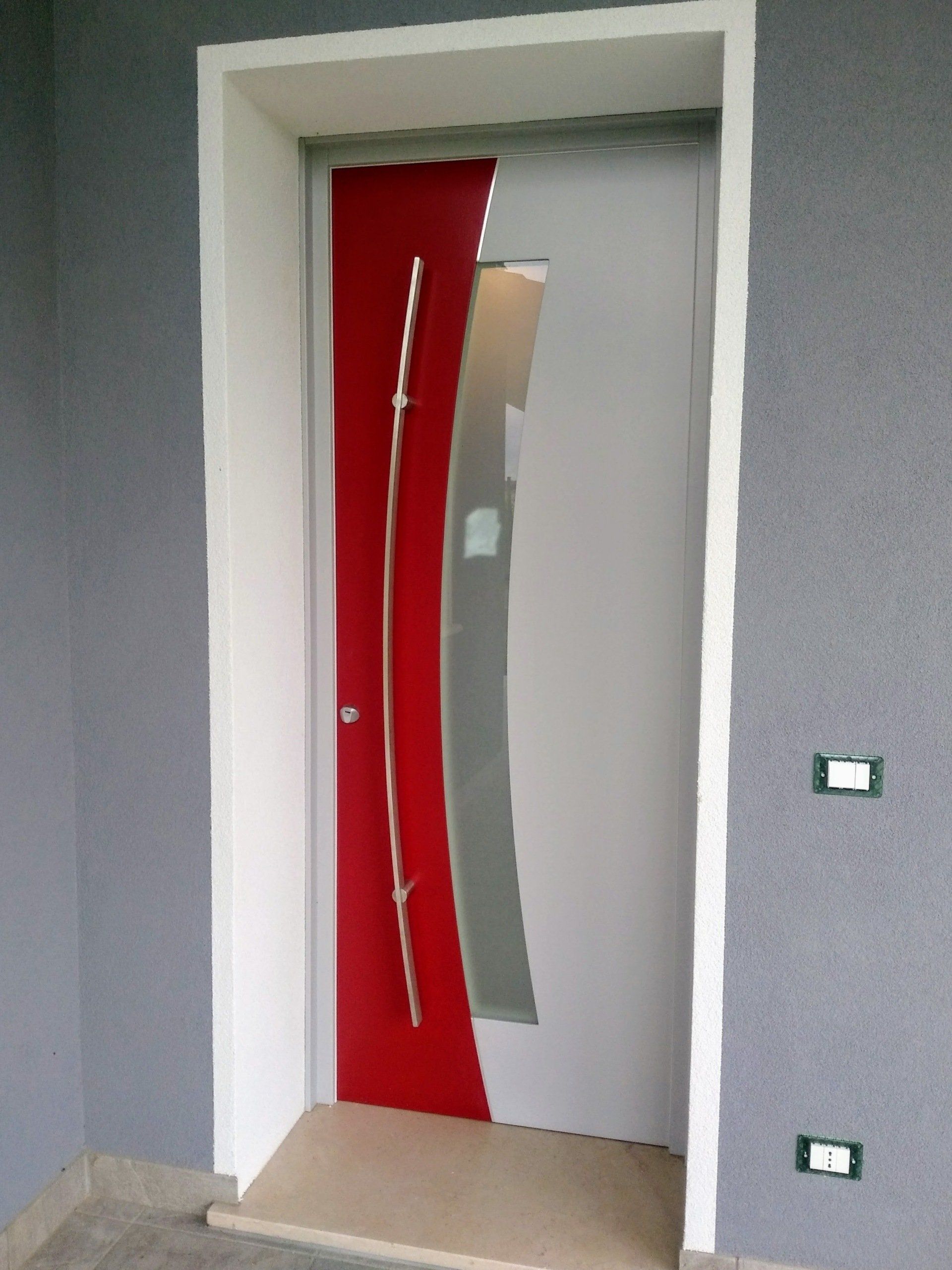 Una porta rossa e bianca con una maniglia in acciaio inossidabile