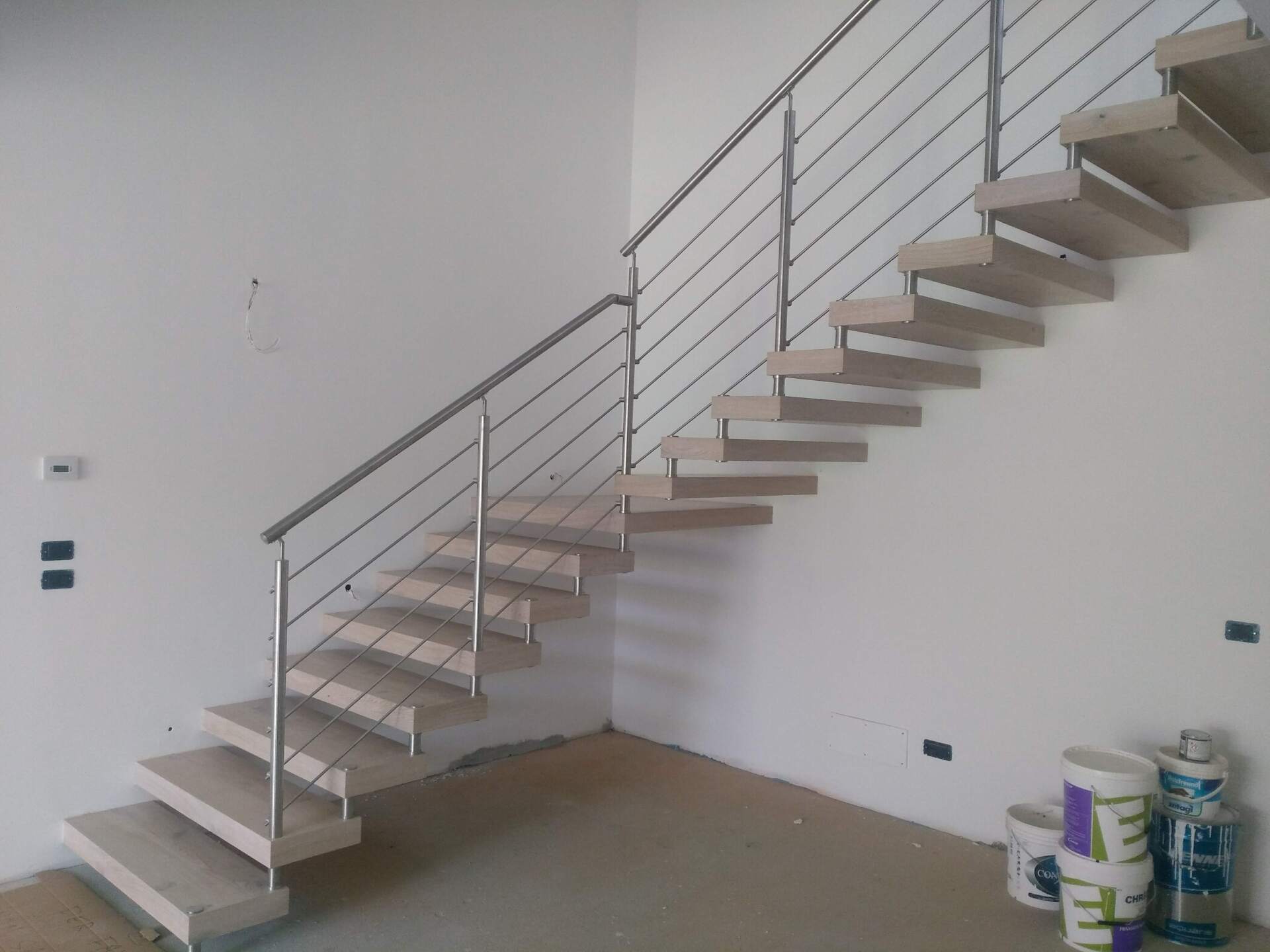 Una scala con ringhiera in acciaio inox in una stanza