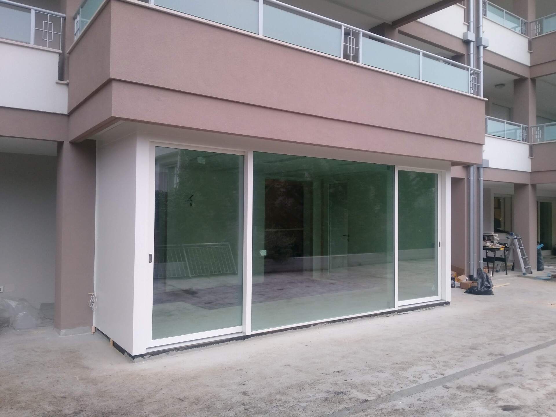 Un edificio con porte scorrevoli in vetro e un balcone