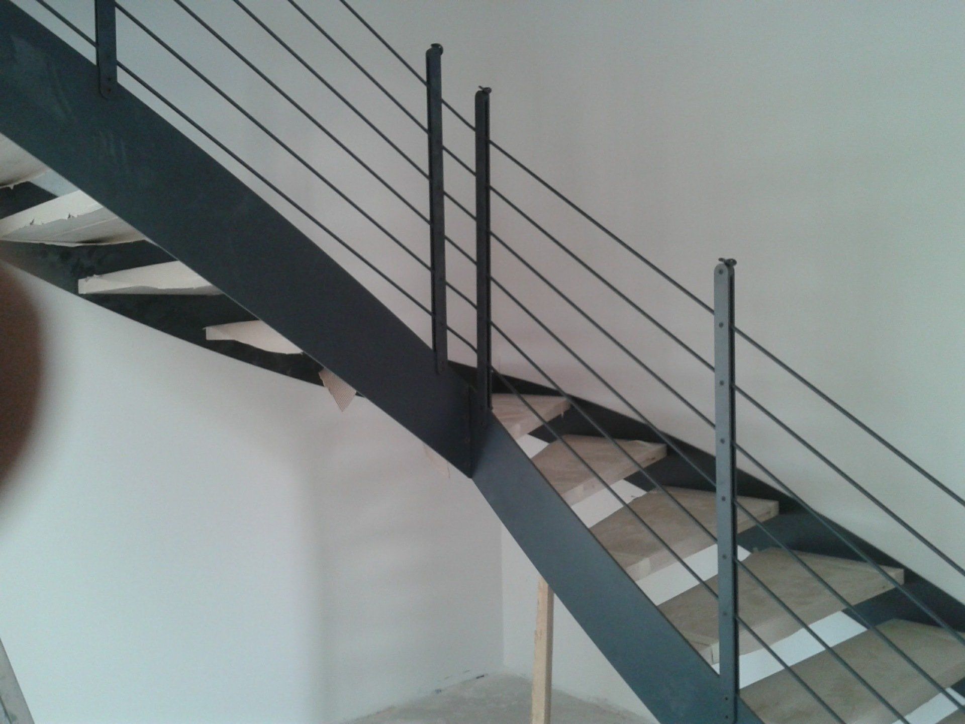 Una scala con una ringhiera di metallo in una stanza