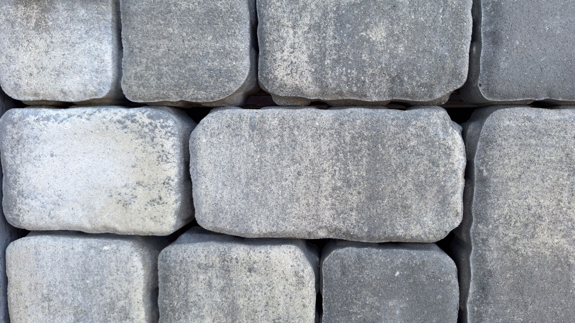 Close-up of grey rectangular pavers in a stacked pattern.