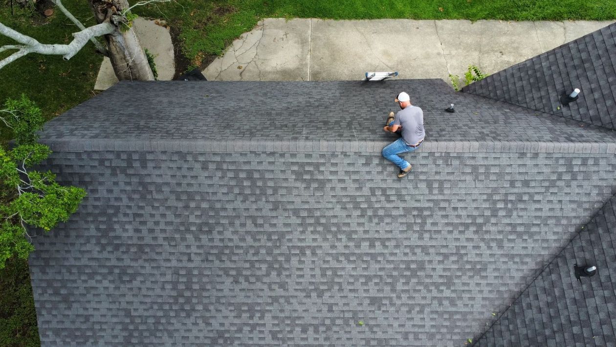 An aerial view of a man sitting on top of a roof.
