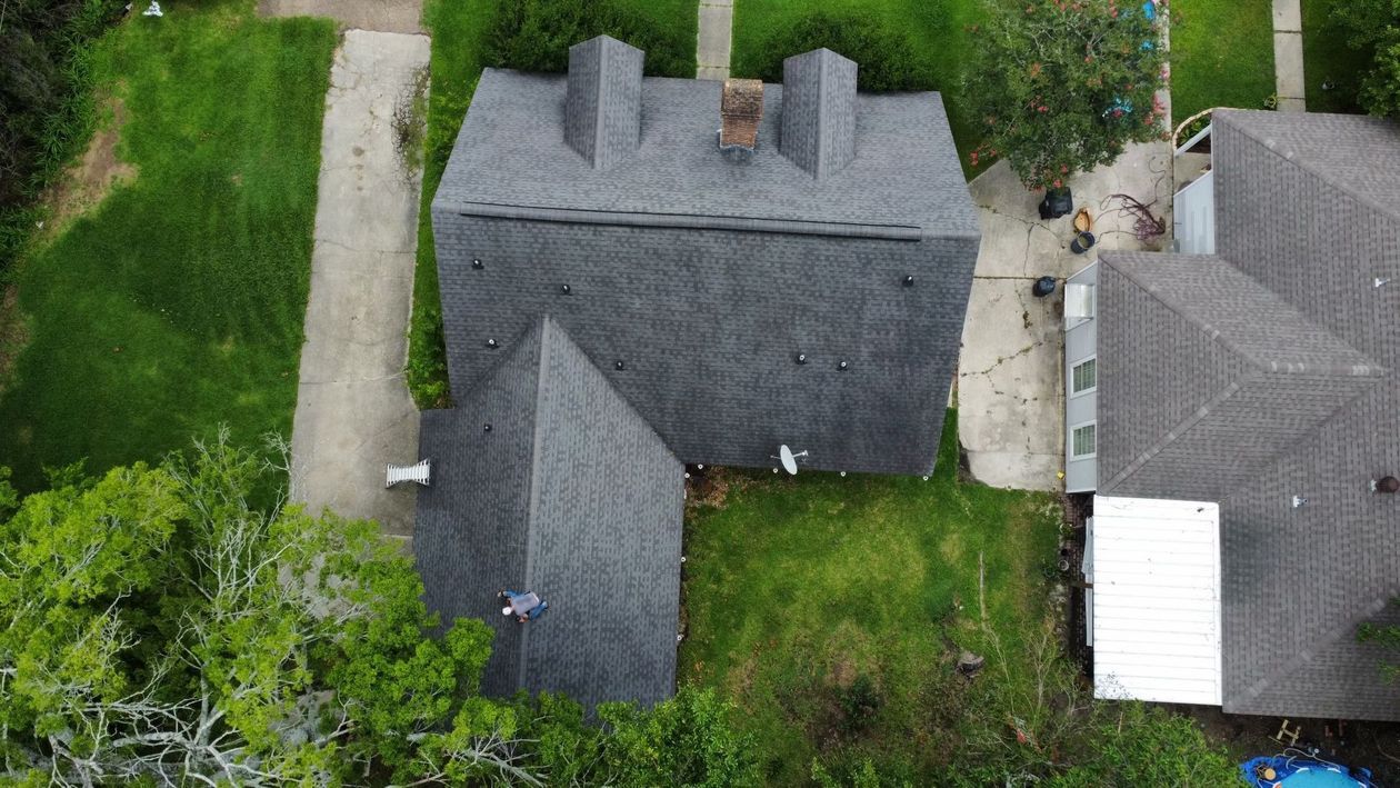 An aerial view of a house with a roof that is covered in shingles.