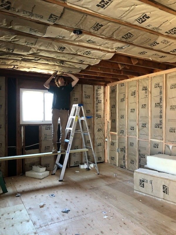 Elegant white bathroom with a double vanity, mirrors, and a tiled shower.