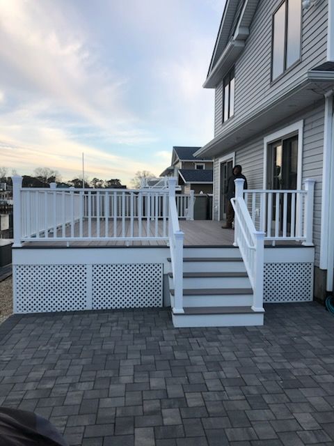 Modern kitchen with island, bar stools, light wood cabinets, and pendant lights.