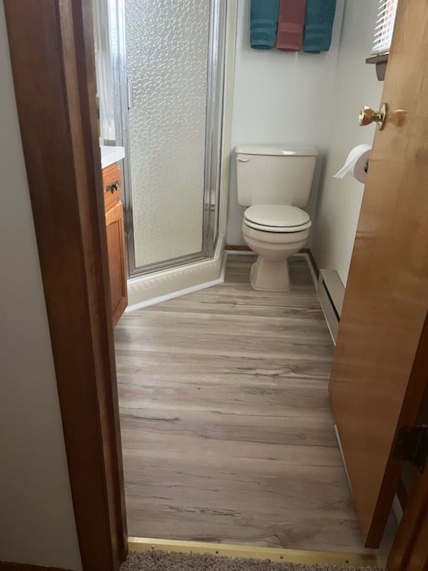 Close-up of glossy, light-brown hardwood flooring with visible wood grain.