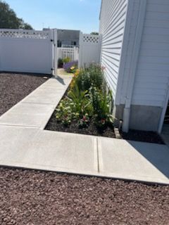 Diamond-patterned gray and dark gray pavement with green grass alongside.
