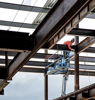A construction worker is working on a steel structure