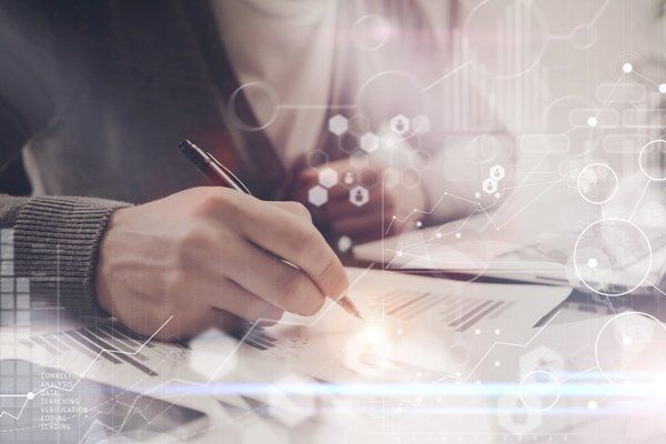 אדם כותב על פיסת נייר בעט.